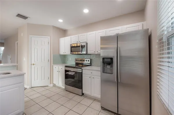 a kitchen with stainless steel appliances granite countertop a refrigerator and a stove top oven
