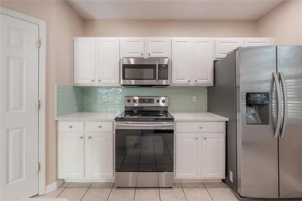 a kitchen with stainless steel appliances granite countertop a refrigerator stove and sink