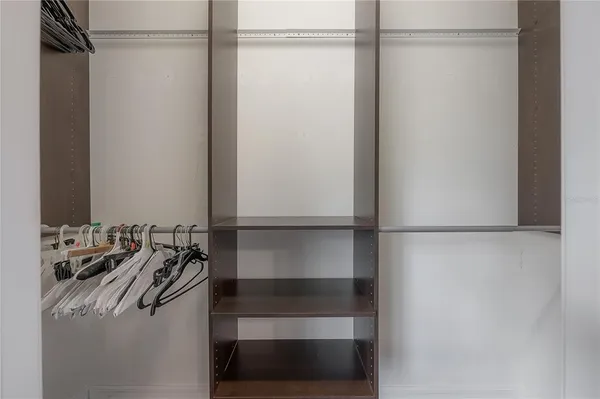 a view of walk in closet with empty racks