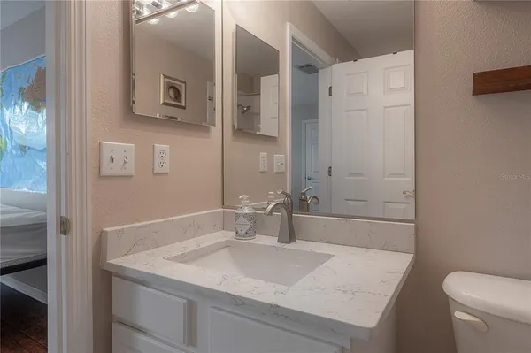 a bathroom with a granite countertop sink toilet and shower