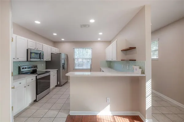 a kitchen with stainless steel appliances a microwave a sink and a refrigerator