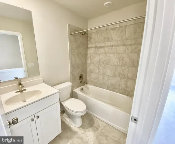 a spacious bathroom with a granite countertop sink toilet and shower