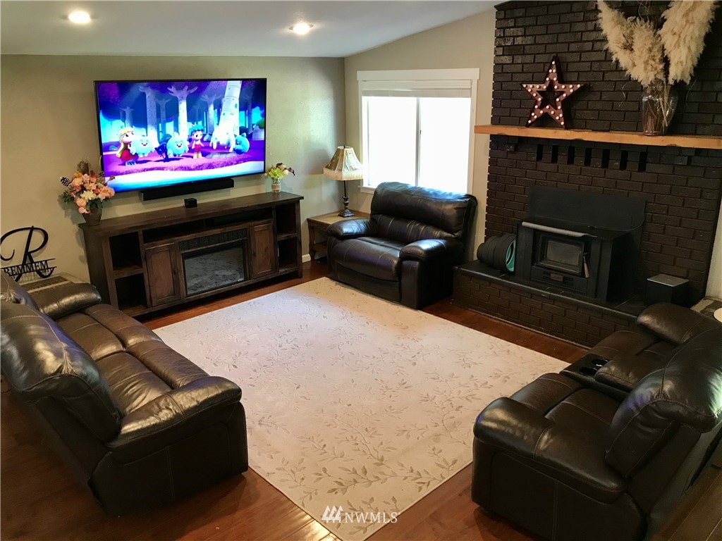 173 River Heights Road Centralia, WA 98531 - Photo 11 of 40 a living room with furniture a flat screen tv and a fireplace