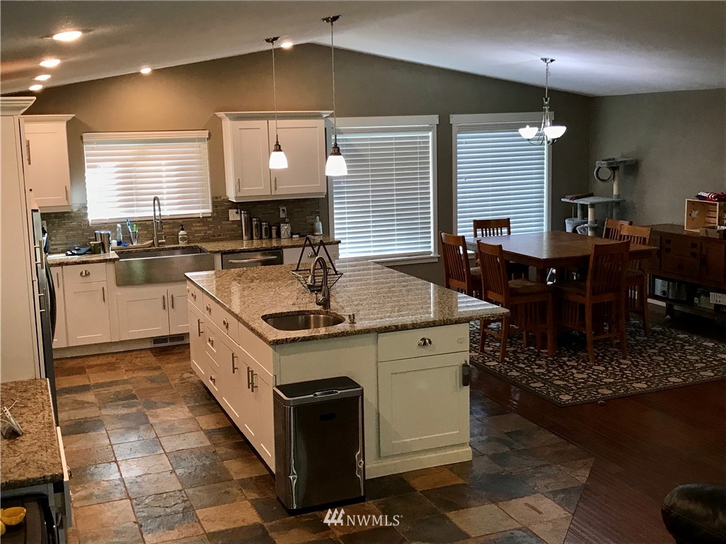 173 River Heights Road Centralia, WA 98531 - Photo 8 of 40 a kitchen with a stove a sink a refrigerator and chairs