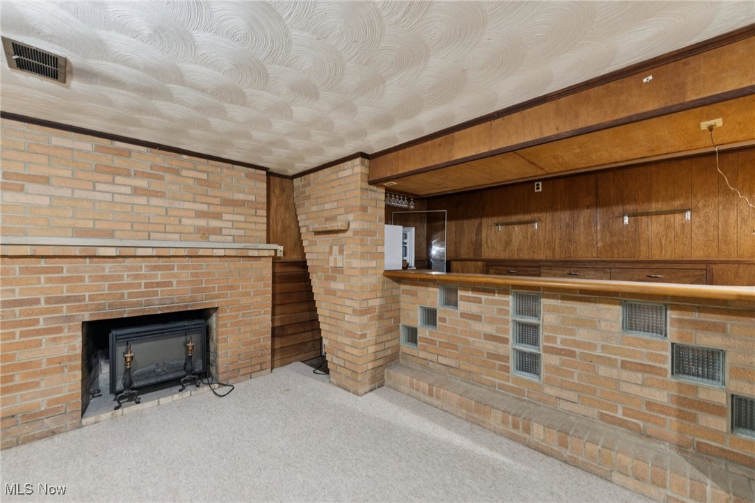 481 Meadowlane Road Independence, OH 44131 - Photo 16 of 40 Basement of main house has basement with finished rec room. Note attractive brick accents with wet bar, refrigerator, cabinets and gas fireplace.