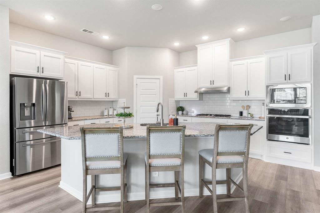1609 Cotton Road Van Alstyne, TX 75495 - Photo 4 of 27 a kitchen with a sink stainless steel appliances and white cabinets