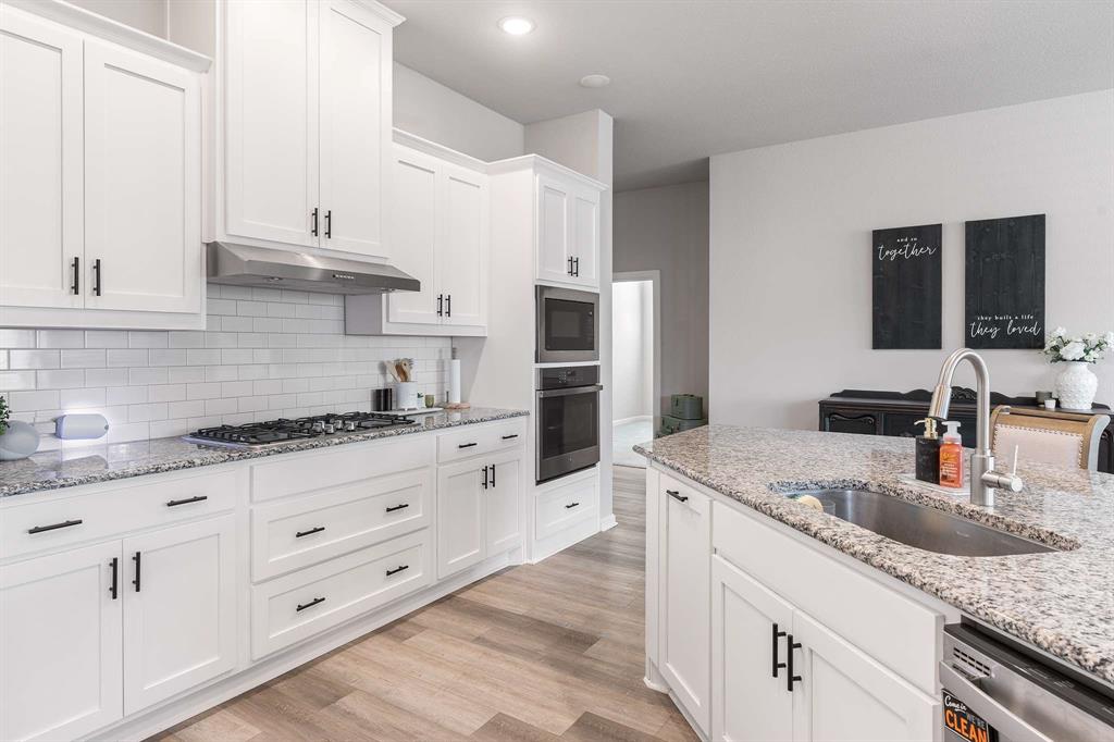 1609 Cotton Road Van Alstyne, TX 75495 - Photo 10 of 27 a kitchen with granite countertop a sink stove and cabinets