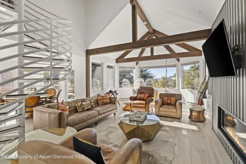 a living room with furniture a fireplace and a large window