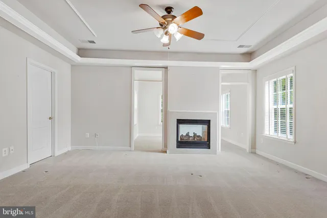 a view of a livingroom with a fireplace a ceiling fan and a fireplace