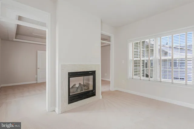 a living room with a fireplace and a floor to ceiling window