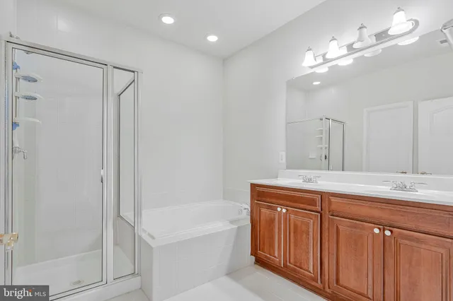 a bathroom with a granite countertop sink a mirror a shower and a bathtub