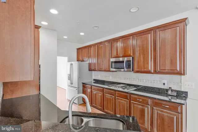 a kitchen with stainless steel appliances granite countertop a stove a sink and a microwave
