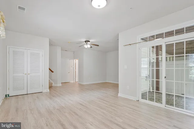 an empty room with wooden floor and windows