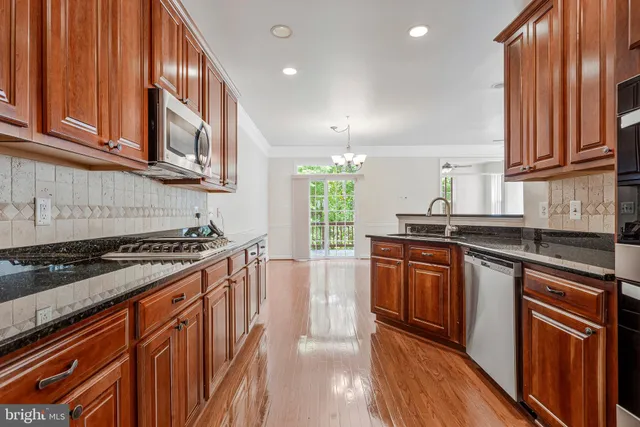 a kitchen with stainless steel appliances granite countertop a stove a sink dishwasher and a refrigerator