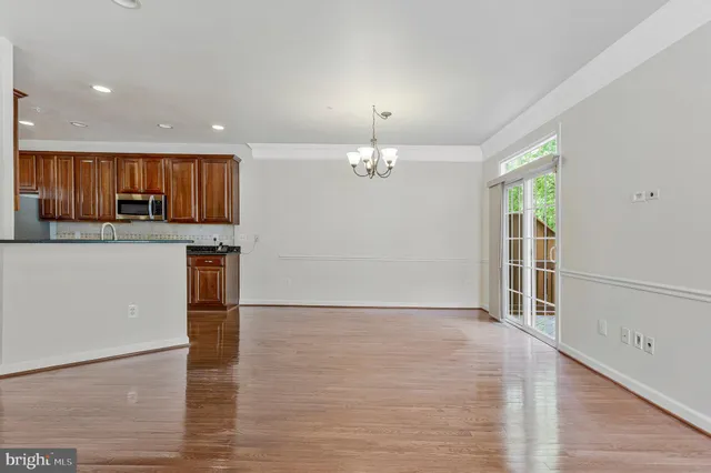 a view of a kitchen with a sink wooden cabinets and a refrigerator