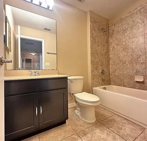 a bathroom with a sink a toilet a mirror and bathtub
