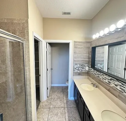 a spacious bathroom with a granite countertop sink and a large mirror