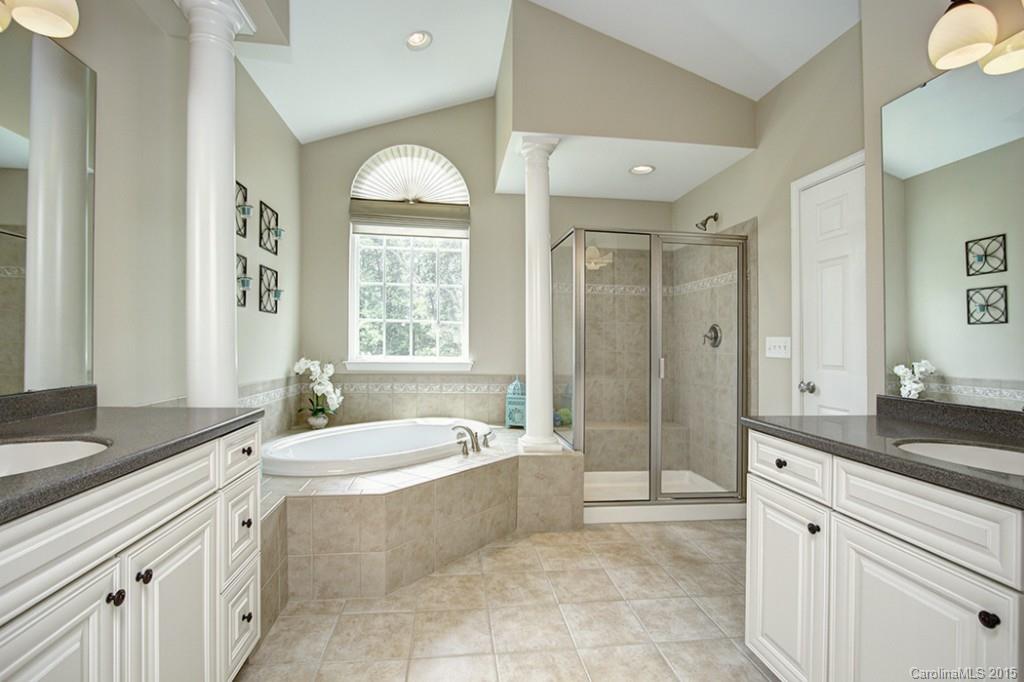 674 Reliance Court Tega Cay, SC 29708 - Photo 15 of 24 a spacious bathroom with a granite countertop tub sink a mirror a shower and a bathtub