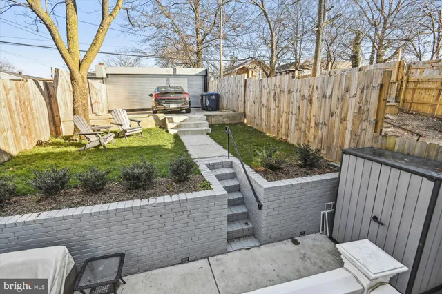 a view of a house with backyard and wooden fence