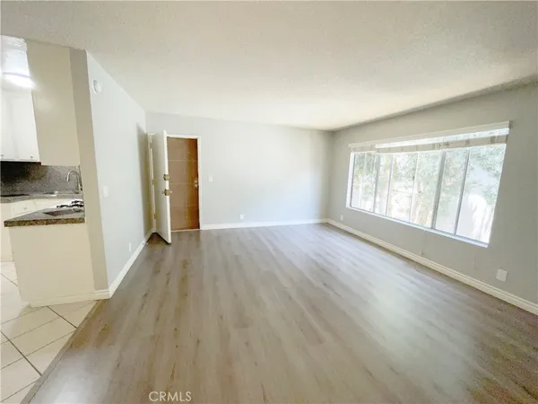 an empty room with wooden floor and a window