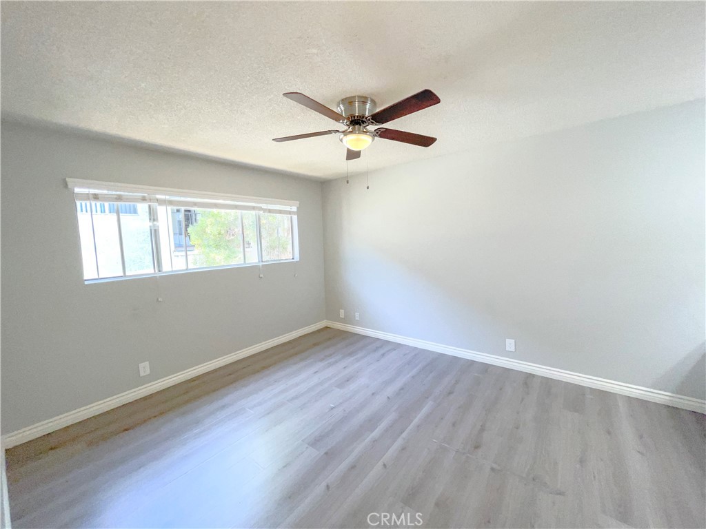 13717 Chadron Avenue, Unit 16 Hawthorne, CA 90250 - Photo 6 of 11 an empty room with wooden floor ceiling fan and windows