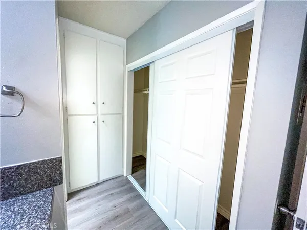 a view of a hallway with wooden floor and closet