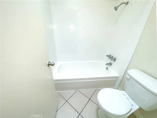 a white toilet sitting next to a bath tub
