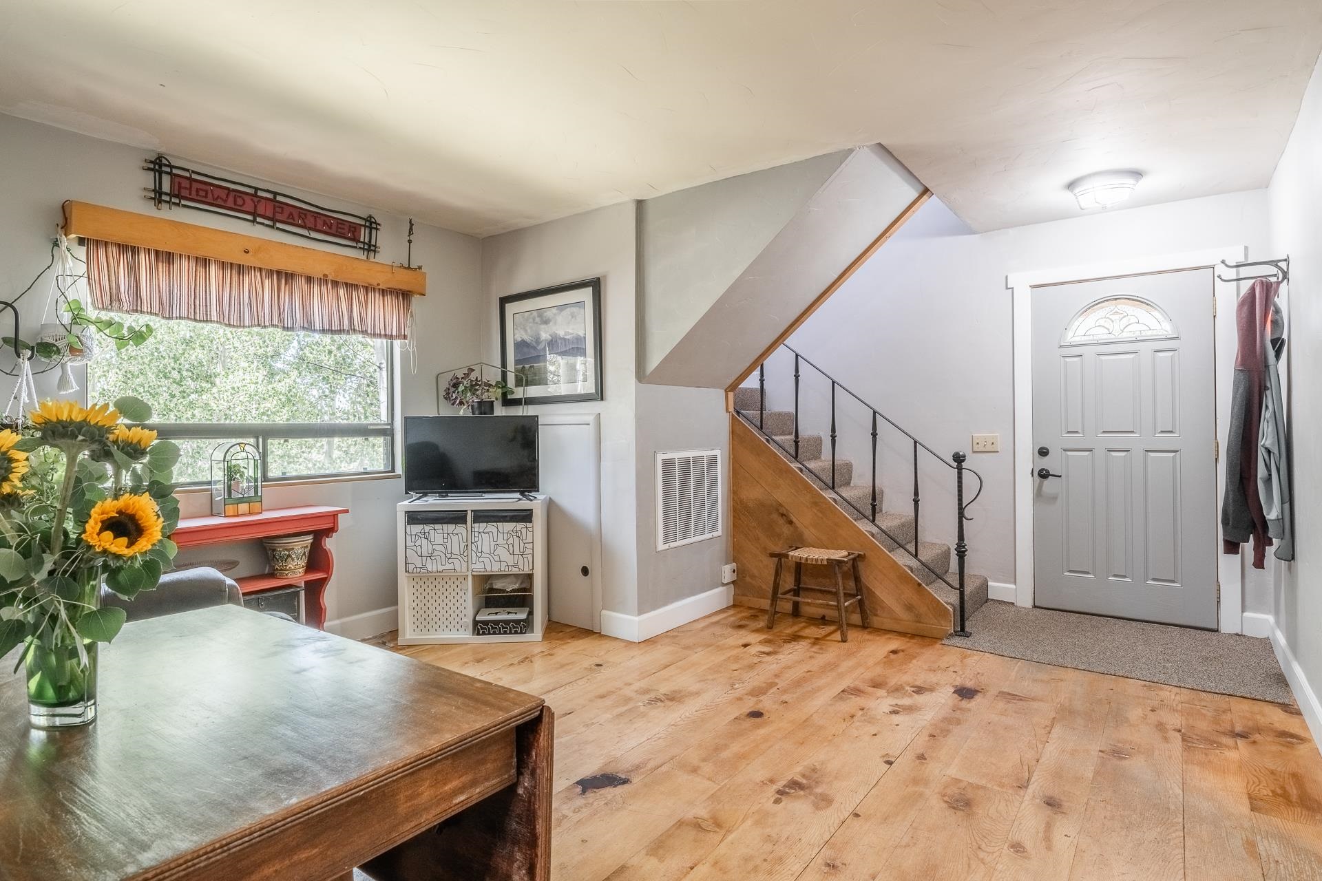 537 Aspen Spring Ranch Road Mammoth Lakes, CA 93546 - Photo 18 of 40 Spacious interior featuring wood-finish flooring, a contemporary staircase with wrought iron railing, and a front entry door with an arched glass insert