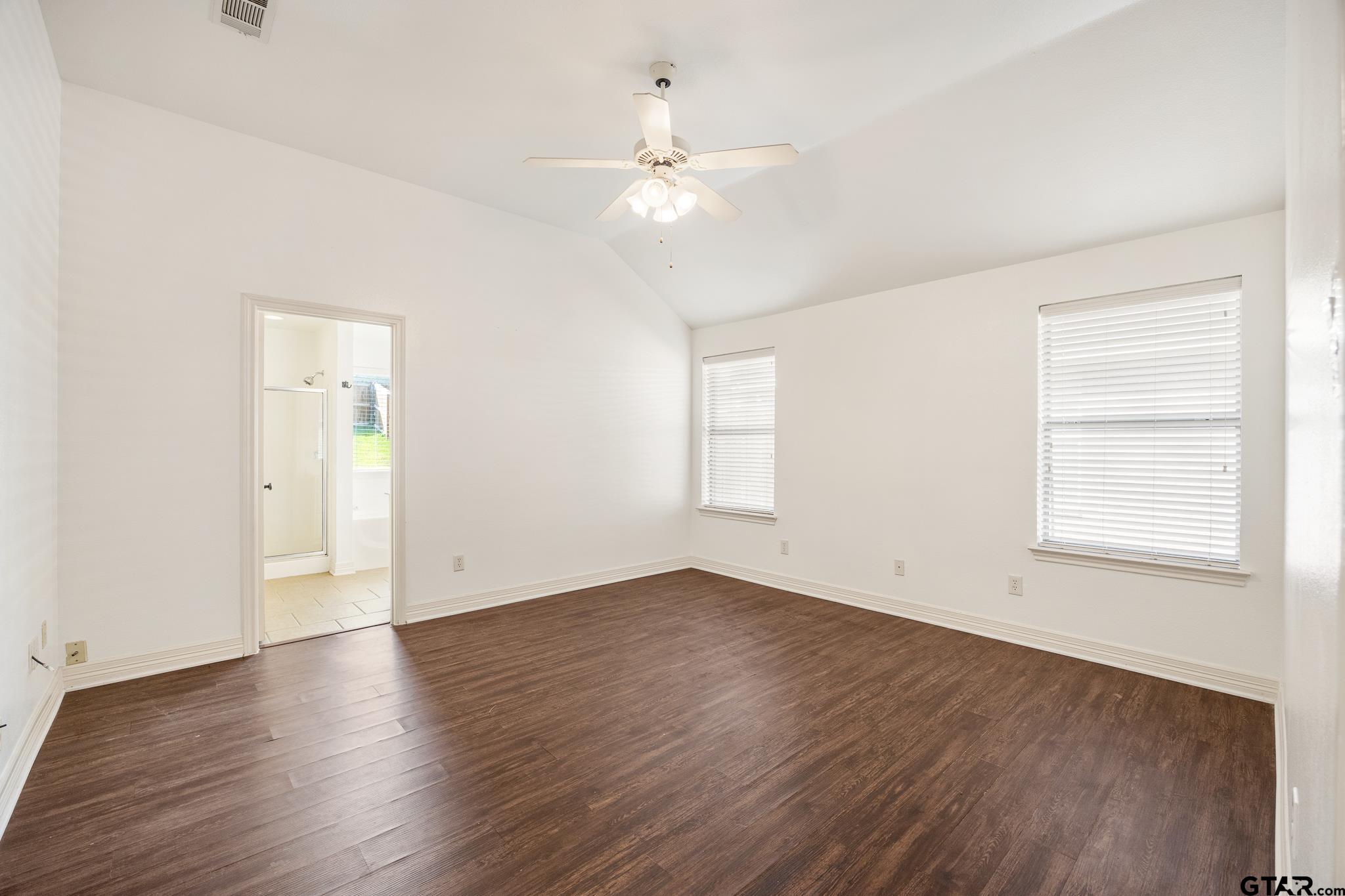 209 Cass Circle Tyler, TX 75703 - Photo 15 of 33 an empty room with wooden floor chandelier fan and windows