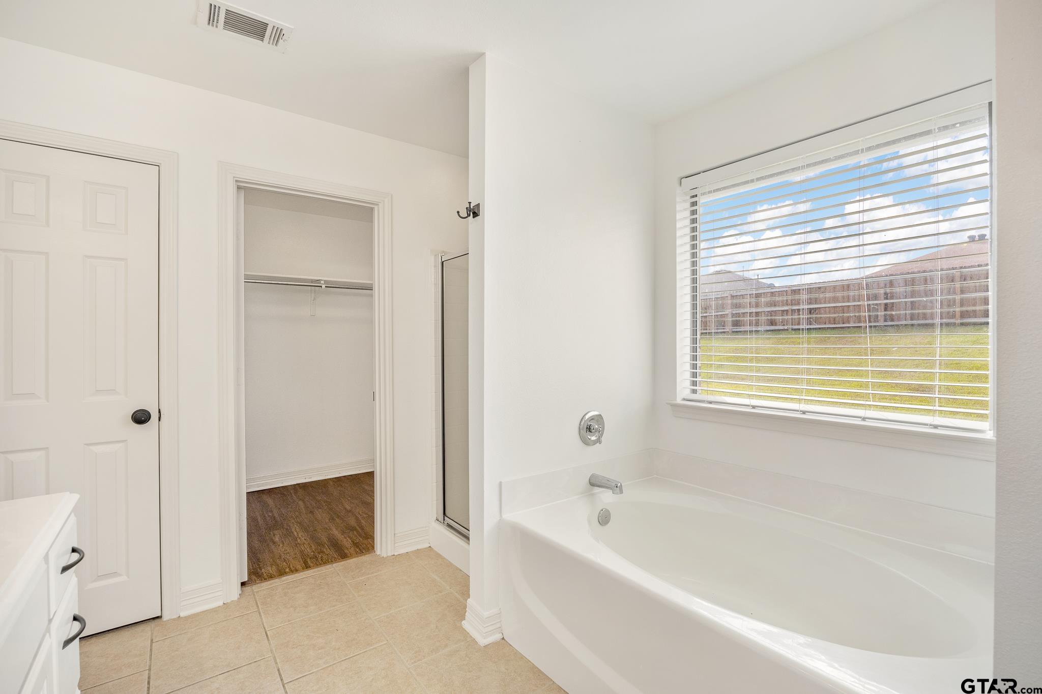 209 Cass Circle Tyler, TX 75703 - Photo 19 of 33 a bathroom with a bathtub and a shower