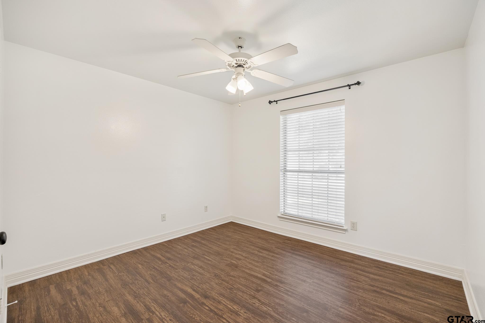 209 Cass Circle Tyler, TX 75703 - Photo 24 of 33 an empty room with wooden floor fan and windows