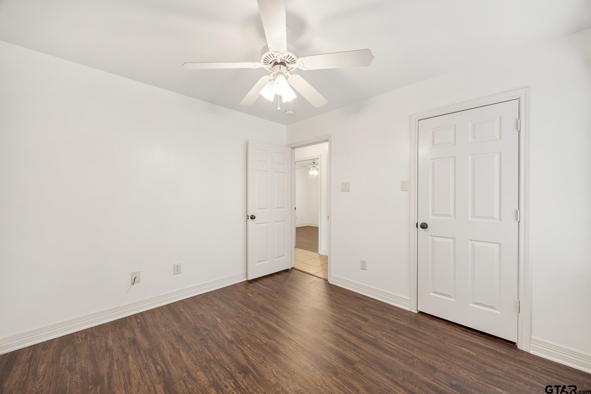 209 Cass Circle Tyler, TX 75703 - Photo 27 of 33 an empty room with wooden floor and fan