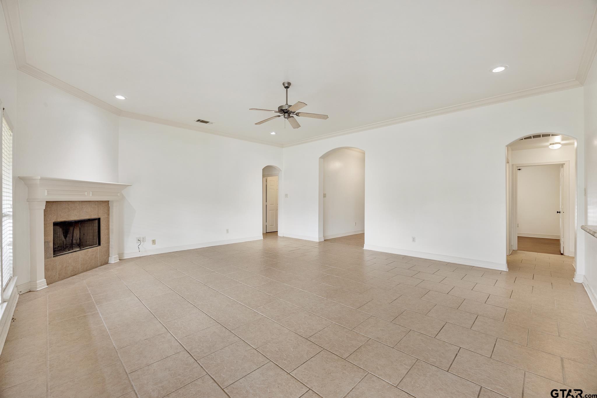 209 Cass Circle Tyler, TX 75703 - Photo 5 of 33 an empty room with fan and a fireplace