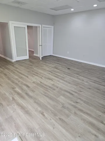 a view of an empty room with wooden floor