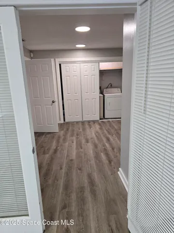 a view of a hallway to a room with wooden floor