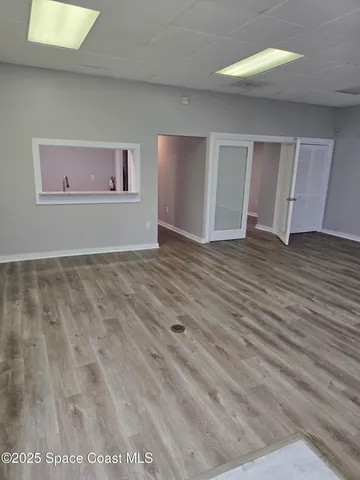 a view of empty room with wooden floor