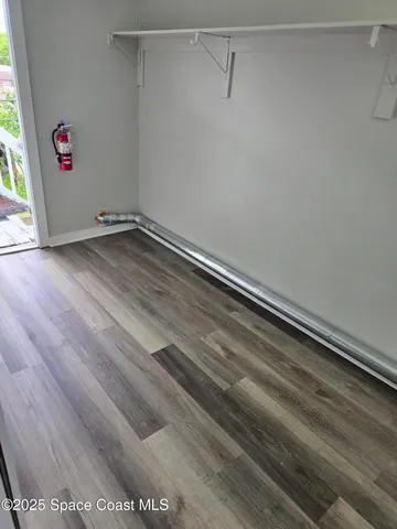 a view of a closet with wooden floor