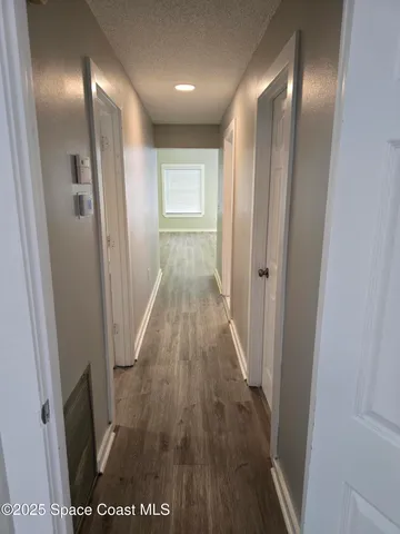 a view of a hallway with wooden floor