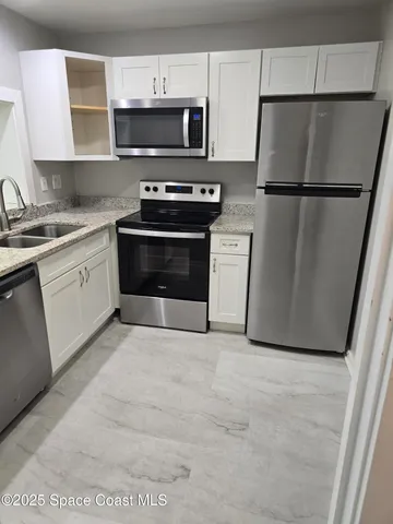 a kitchen with a refrigerator stove and microwave