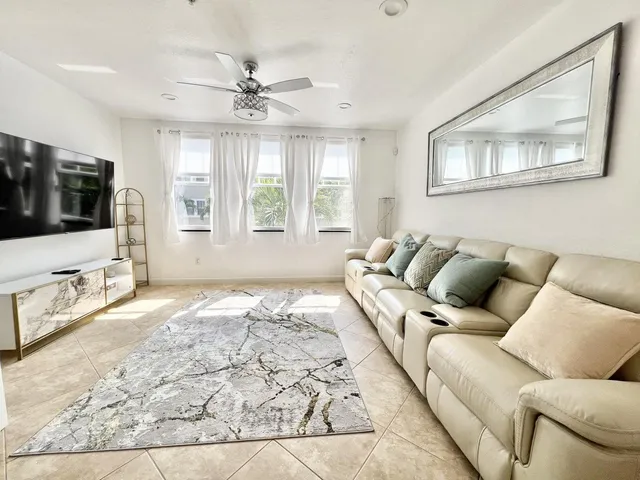 a living room with a bed furniture and a flat screen tv