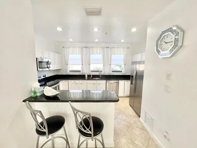 a kitchen with stainless steel appliances granite countertop a sink and a stove top oven