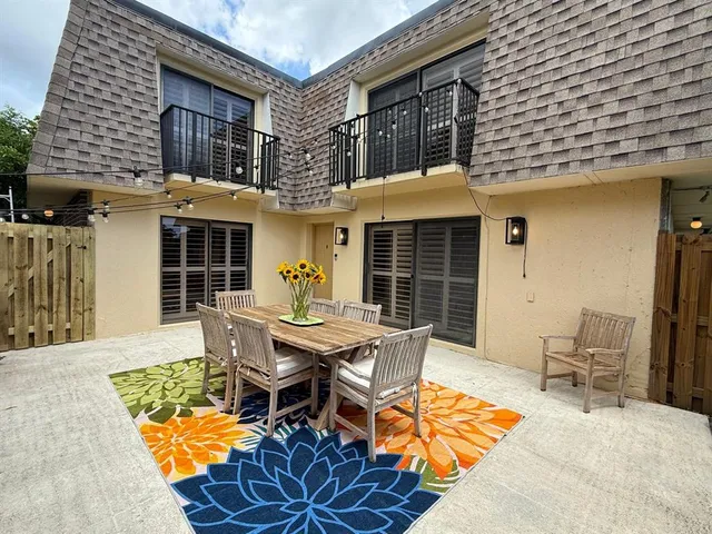 a backyard of a house with table and chairs