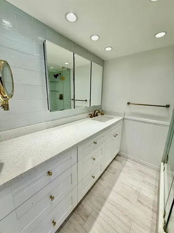 a bathroom with a granite countertop sink toilet and shower
