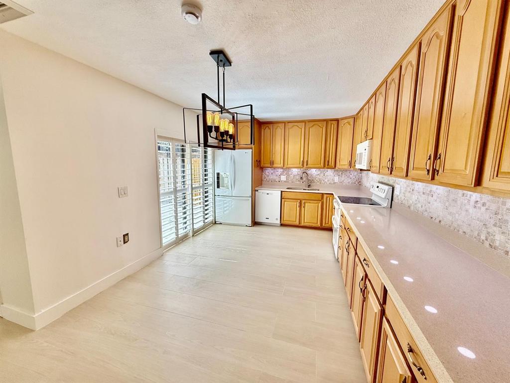 2911 Southwest 22nd Circle, Unit 37B Delray Beach, FL 33445 - Photo 10 of 51 a view of a kitchen with a sink and dishwasher with wooden floor