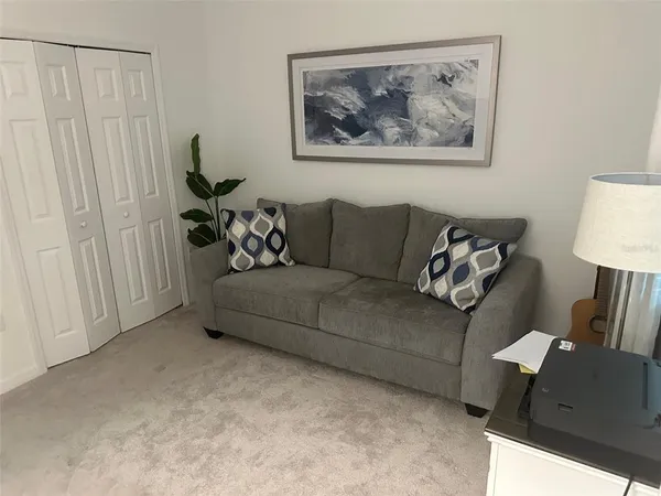 a living room with furniture and a painting on the wall