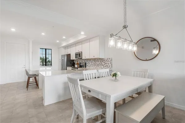 a kitchen with a dining table chairs and white cabinets