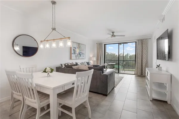 a dining room with furniture a chandelier and window
