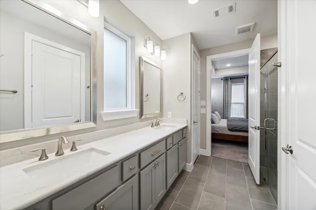 a en suite bathroom with a double vanity sink and mirror