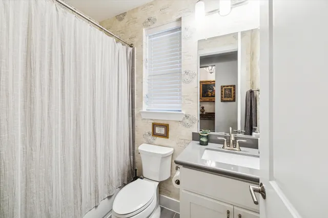 a bathroom with a sink a toilet and shower curtain