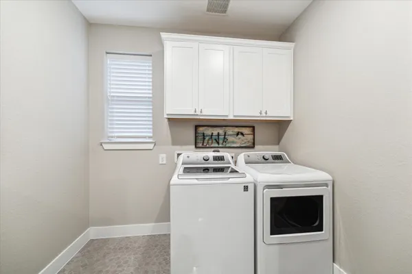 a view of washer and dryer with bathroom in the background